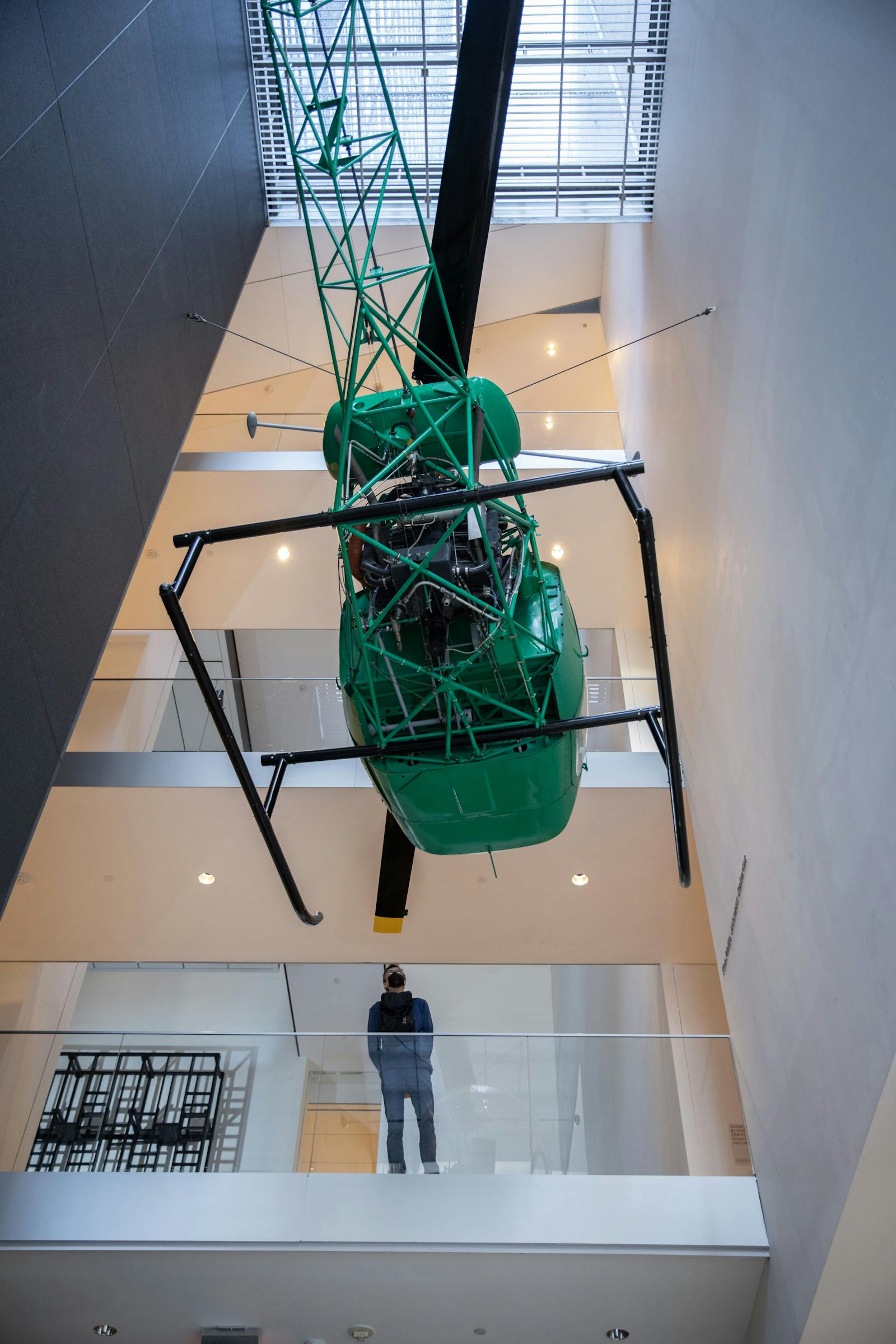 Widok z dołu na zielony helikopter zawieszony w MoMA